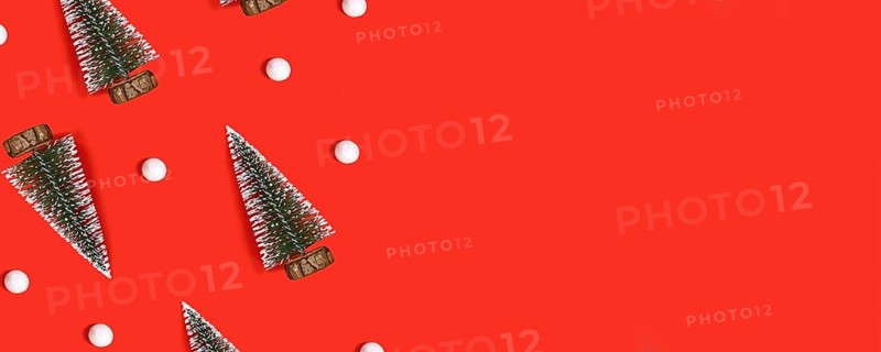 Red Christmas banner with trees and snowballs on red background with copy space