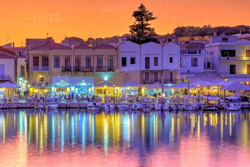 Venetian harbour, dusk, night shots, orange sky, colourful rows of houses, boats, water reflection, artificial light, Rethimnon, central Crete, island of Crete, Greece, Europe