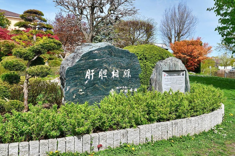 Freiburg, Germany, April 2022: Memorial stone with inscription in Japanese garden in public park called 'Seepark', Europe