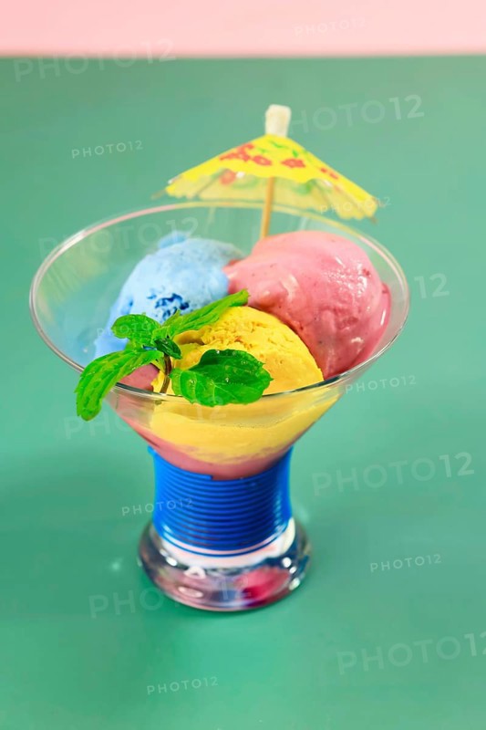 Homemade ice cream in a glass bowl with mint and umbrella, summer, Germany, Europe