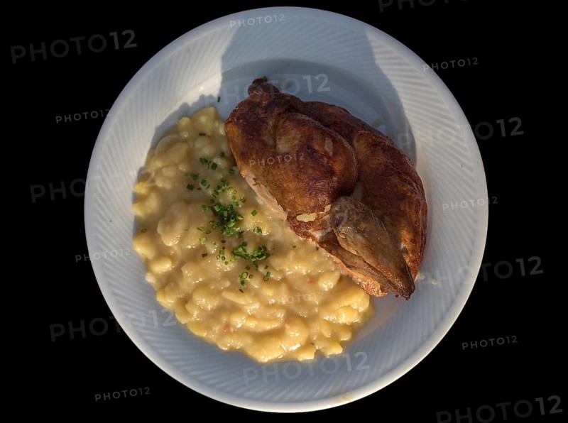 Half baked chicken with potato salad on a black background, Bavaria, Germany, Europe