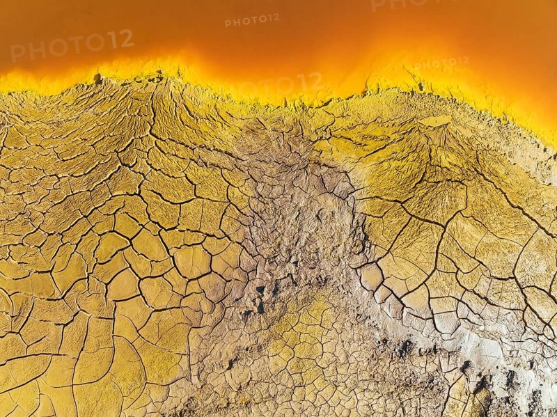 Cracked earth at the bank of the Rio Tinto (Red river) with its deep reddish hue due to oxidised iron minerals in its water, aerial view, drone shot, Huelva province, Andalusia, Spain, Europe
