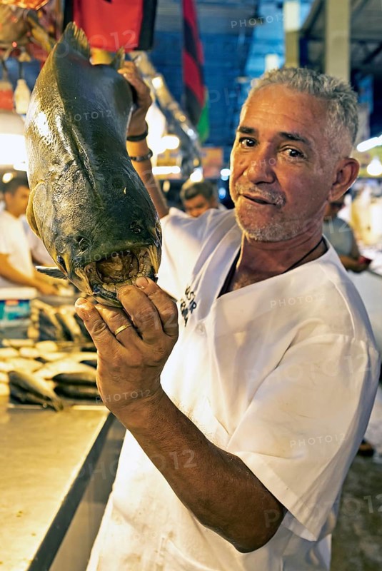Brazilian man showing the large teeth of a black pacu or millstone tetra or tambaqui, Adolpho Lisboa Municipal Market, Manaus, State of Amazonas, Brazil, South America