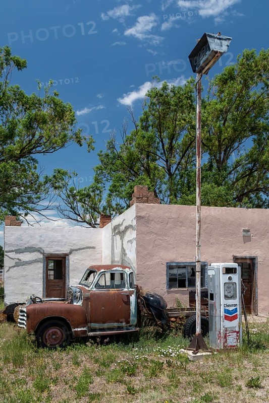 La Jara, Colorado, A rusty, old pickup truck, parked in front of an old Chevron gas station, in southern Colorado