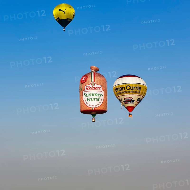 Three hot-air balloons travelling in the blue sky, advertising for Reinert Sommerwurst, BVB, Brian Currie, logo, hot-air balloon festival, 26th Warsteiner International Montgolfiade, evening sky, Warstein, Sauerland, North Rhine-Westphalia, Germany, Europe