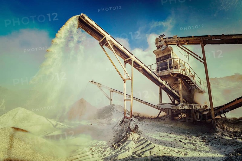 Vintage retro effect filtered hipster style image of Industrial background, crusher rock stone crushing machine at open pit mining and processing plant for crushed stone, sand and gravel
