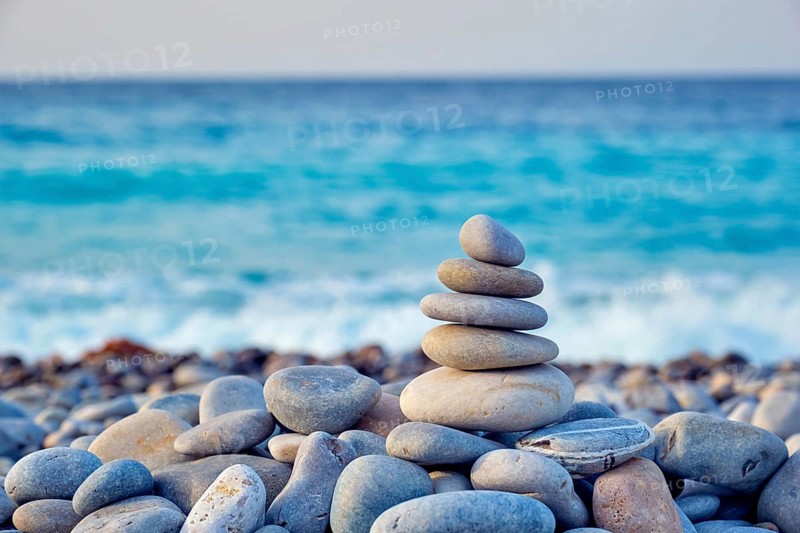 Zen meditation relaxation concept background, balanced stones stack close up on sea beach