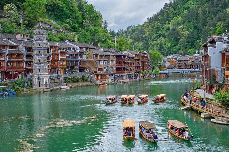 Chinese tourist attraction destination, Feng Huang Ancient Town (Phoenix Ancient Town) on Tuo Jiang River with Wanming Pagoda tower and tourist boats. Hunan Province, China, Asia