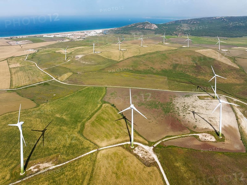 Windmills on a wind farm, in the distance Zahara de los Atunes and the coastline of the Atlantic Ocean, aerial view, drone shot, Cádiz province, Andalusia, Spain, Europe