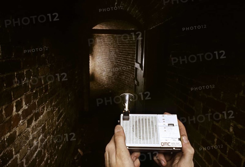 Man using bat detector in old cellar, icehouse for research