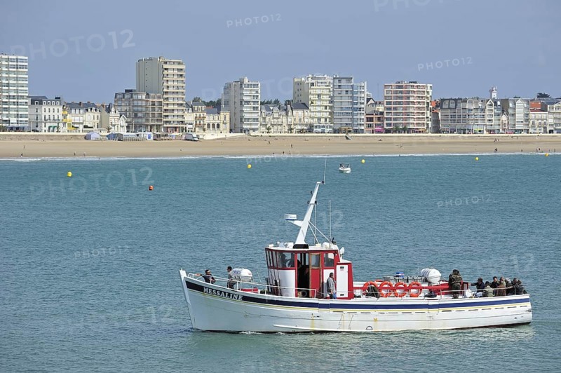 Fishing boat with sea anglers and apartments at Les Sables-d'Olonne, La Vendée, Pays de la Loire, France, Europe
