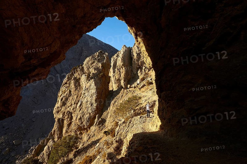 Hiker on hiking trail small, rock gate, Gingilos, hiking on the Gingilos, morning light, Samaria Gorge, Omalos, Lefka Ori, White Mountains, West Crete, island of Crete, Greece, Europe