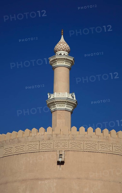 Mosque tower and parapet of the old fort of Nizwa. Nizwa is the centre of the Omani heartland. The oasis town lies on the southern edge of the Hajar Mountains near the Jabal al-Achdar, the highest mountain range in Oman