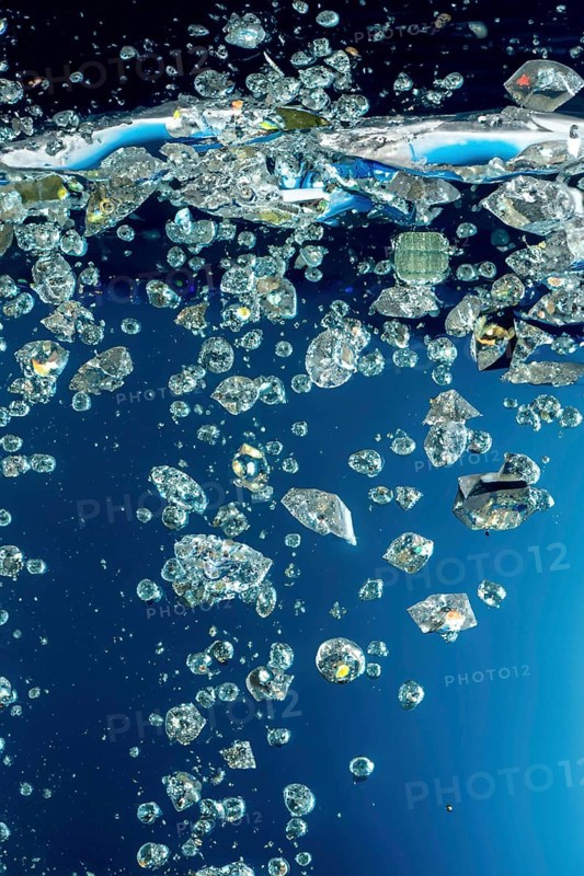 Diamonds falling into the water with splashes, bubbles, AI generated