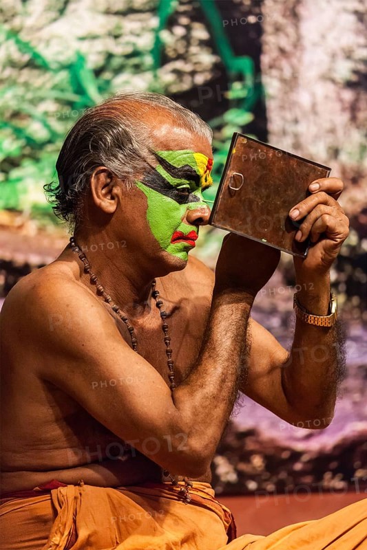 KOCHI, INDIA, FEBRUARY 24, 2013: Unidentified Kathakali exponent preparing for performance by applying face make-up. Kathakali is the classical dance form of Kerala
