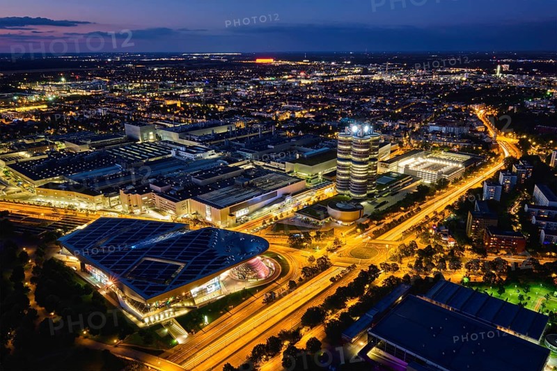 MUNICH, GERMANY, JULY 08, 2018: Aerial view of BMW Museum and BWM Welt and factory and Munich from Olympic Tower illuminated at night. BMW is a famous German luxury car automaker
