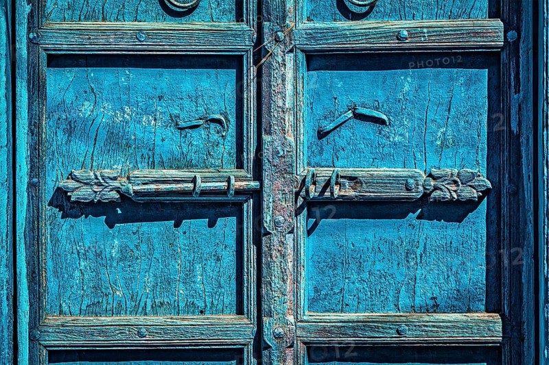 Latch with padlock on old textured door in India