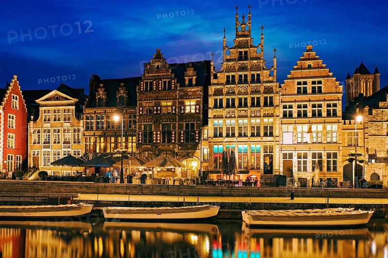 Old houses on Graslei street, canal and tourist boatds in the evening. Ghent, Belgium, Europe