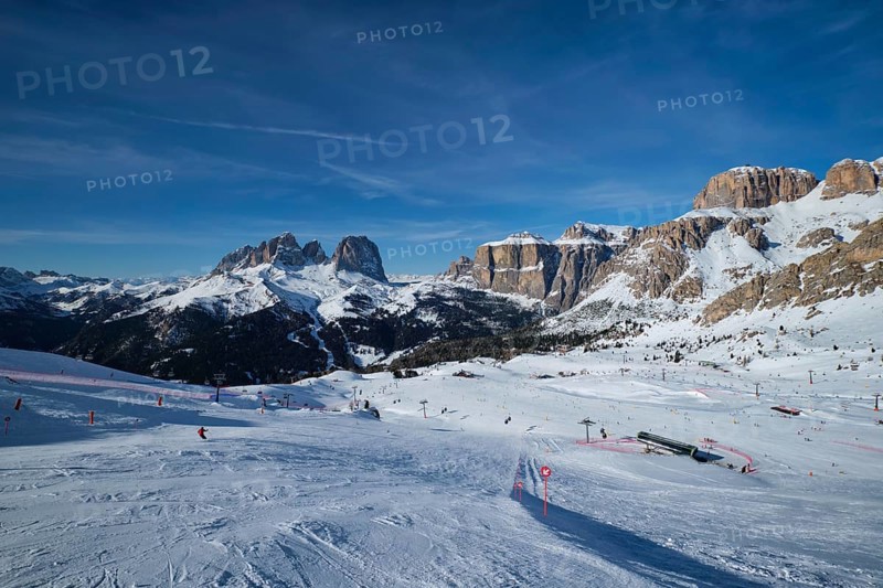 View of a ski resort piste with people skiing in Dolomites in Italy. Ski area Belvedere. Canazei, Italy, Europe
