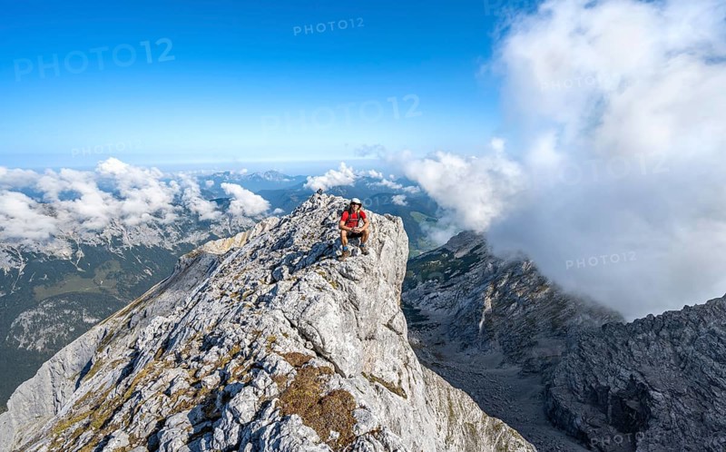 Mountaineer on a rocky narrow mountain path with mountain panorama, mountain tour to the summit of the Hochkalter, Hochkalter crossing, Berchtesgaden Alps, Bavaria, Germany, Europe