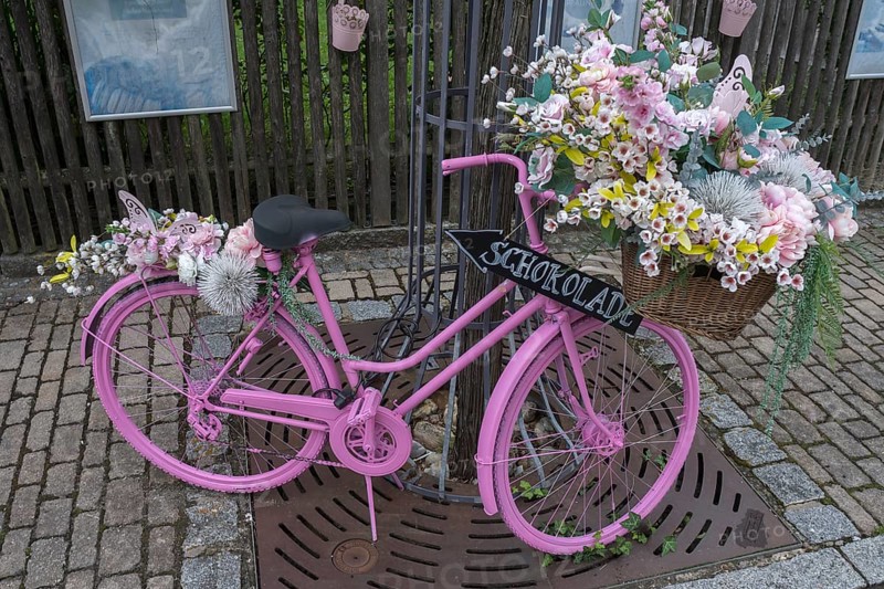 Pink coloured bicycle decorated with artificial flowers, Bavaria, Germany, Europe