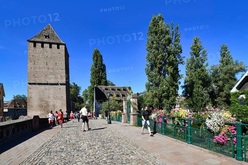 Strasbourg, France, September 2023: People crossing beautiful historic 'Ponts Couvert' bridge with tower on sunny day, Europe