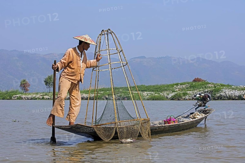 Intha fisherman steering traditional fishing boat by wrapping his leg around the oar, Inle Lake, Nyaungshwe, Shan State, Myanmar, Burma, Asia