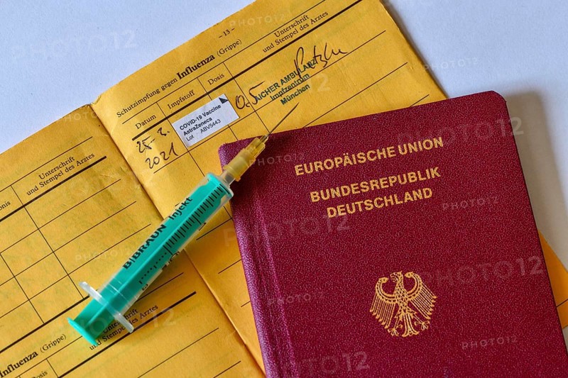 Passport, syringe and vaccination certificate with entry for vaccination with AstraZeneca against Covid-19, Sars-CoV-2, Corona virus, pandemic, Germany, Europe