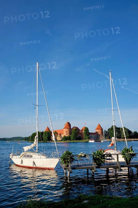 Yacht boats and Trakai Island Castle in lake Galve in day, Lithuania. Trakai Castle is one of major tourist attractions of Lituania