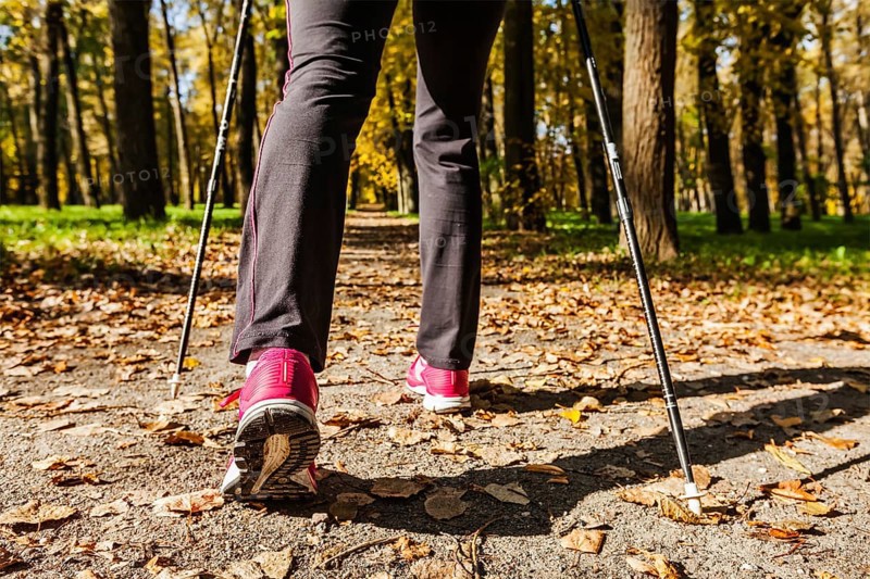 Nordic walking adventure and exercising concept, woman hiking, legs and nordic walking poles in autumn nature
