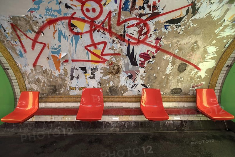 Red seats in the metro in front of a torn down billboard, Paris, France, run down, graffiti, Europe