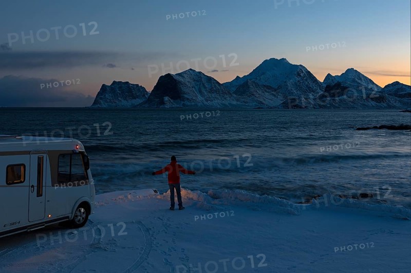 Motorhome in winter on pitch with view of fjord and snow-capped mountains, Storsandnes Beach, Myrland, Lofoten, Norway, Europe