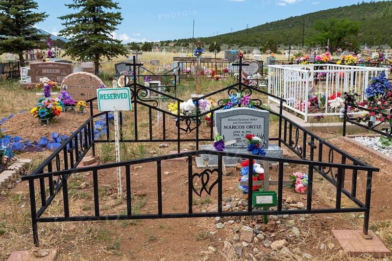 Cerro, New Mexico, A rural cemetery where graves are decorated with flowers and flags. One burial plot is reserved