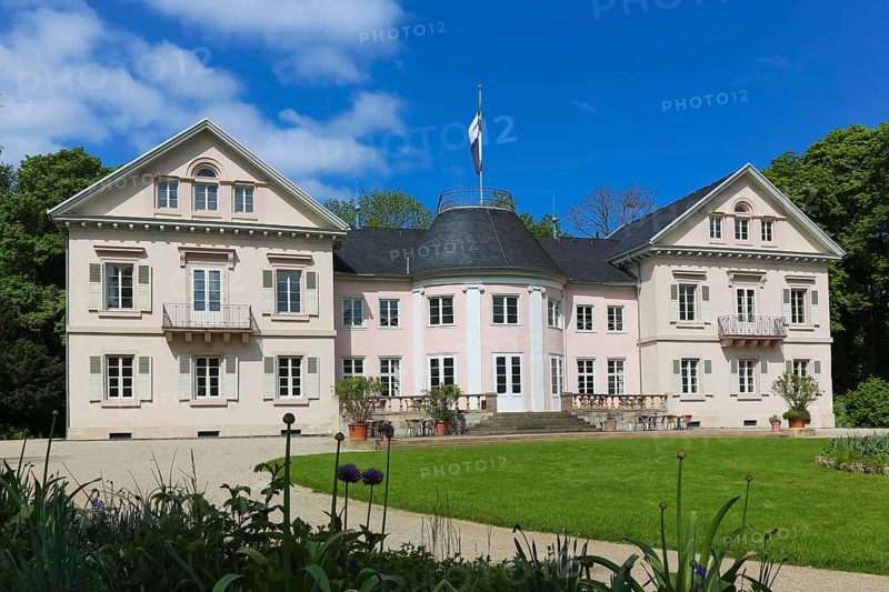 Villa Eugenia, last residence of the Princes of Hohenzollern-Hechingen, classicist central building built from 1786 to 1787 by Prince Joseph Wilhelm as a summer pleasure garden house, side wings added from 1833 to 1834, residence for the then hereditary prince and later princely couple Friedrich Wilhelm Konstantin and Eugenie, meadow, park, garden, historic building, architecture, clouds, sky, flagpole, Hohenzollern coat of arms, Hechingen, Zollernalbkreis, Baden-Württemberg, Germany, Europe