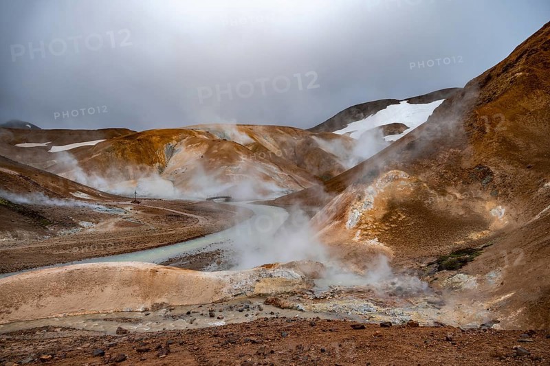 Bridge and steaming streams between colourful rhyolite mountains and snowfields, Hveradalir geothermal area, Kerlingarfjöll, Icelandic Highlands, Iceland, Europe
