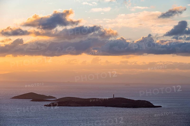 Nisos Gaidaros island with lighthouse in the sea at sunrise with dramatic clouds, Ermoupoli, Syros, Cyclades, Greece, Europe