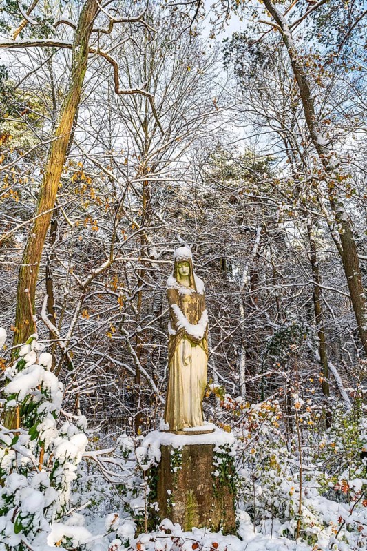 Stone sculpture of a grieving woman in the snow, Südwest-Kirchhof, historic cemetery in Stahnsdorf, Potsdam-Mittelmark, Brandenburg, Germany, Europe