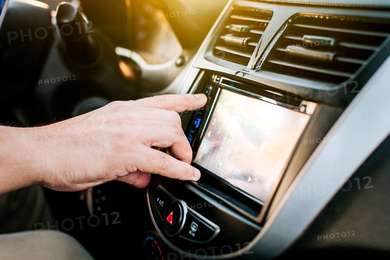Driver hands changing the radio station. Close up of hands changing the car radio station. Concept of driver tuning the radio. Driver man changing radio station