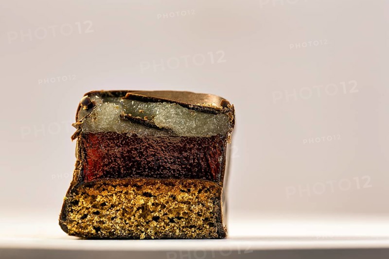Single halved domino, Christmas sweet with layers of marzipan, gingerbread and dark chocolate icing, half, close-up, text space