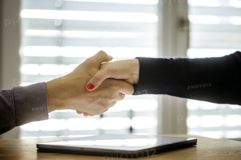 Symbol photo on the subject of concluding a contract. Handshake between man and woman over a tablet with a text document on the screen. Berlin, 13.08.2024