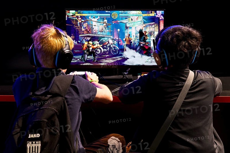 Two young visitors in front of a screen with a computer game, Gamescom trade fair, the world's largest trade fair for computer games and consumer electronics, Cologne, Germany, Europe