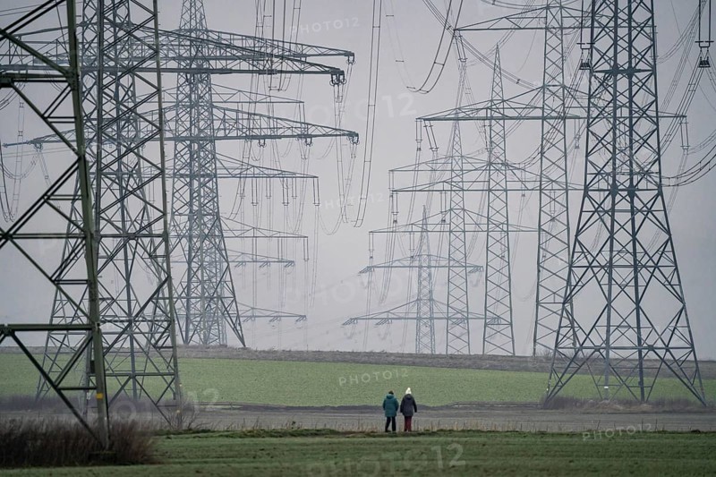 Large power line, 380 KV extra-high voltage lines, near Rommerskirchen, in the fog, winter, walkers on a country lane, North Rhine-Westphalia, Germany, Europe