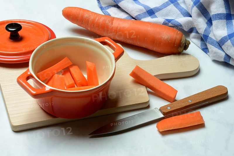 Carrot, carrot sticks in pot and kitchen knife
