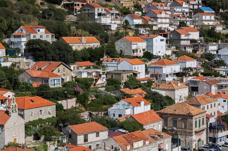 High angle view of tan and white trim houses and villas with traditional terracotta clay tile rooftops on Mount Srd in late summer, Dubrovnik, Croatia, Europe