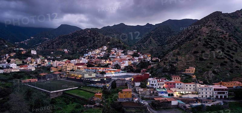 View of Vallehermoso and the surrounding mountain landscape at dusk under a cloudy sky. Vallehermoso, La Gomera, Canary Islands, Spain, Europe
