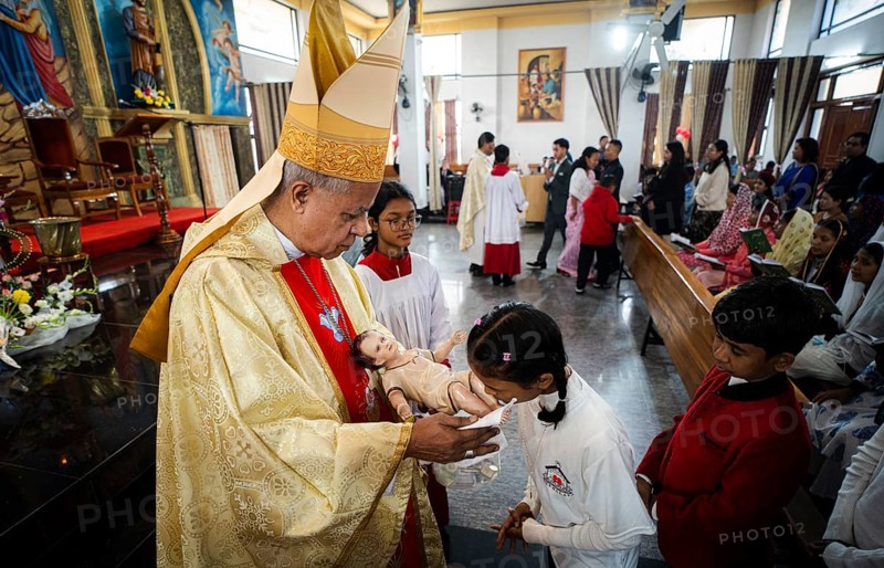 Archbishop John Moolachira holds an idol of baby Jesus Christ as devotees kiss the idol during a Christmas day sermon on December 25, 2024 in Guwahati, India. Christmas is a festive holiday celebrated on December 25th, marking the birth of Jesus Christ in Christian tradition.