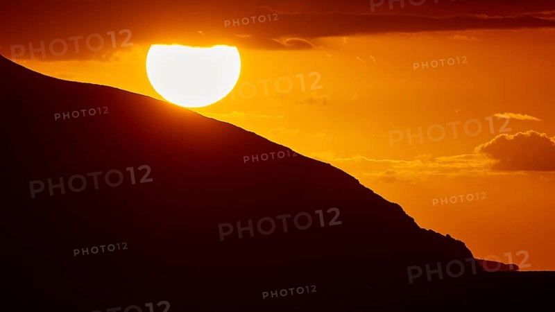 Sinking sun behind a mountain slope, intense orange light in the sky, sunset, Kassos, Karpathos, offshore islands, Dodecanese, Greek Islands, Greece, Europe