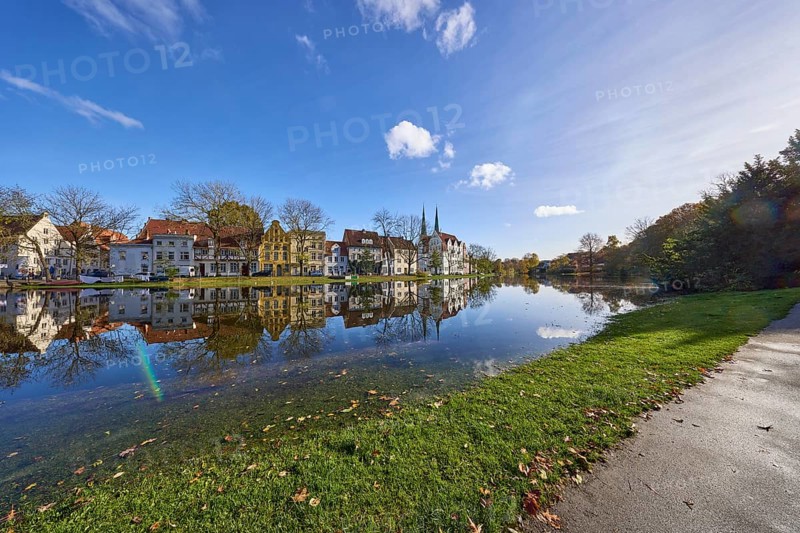 Riverbank of the Trave at high tide, blue sky with cumulus clouds, old town, Hanseatic city of Lübeck, Schleswig-Holstein, Germany, Europe