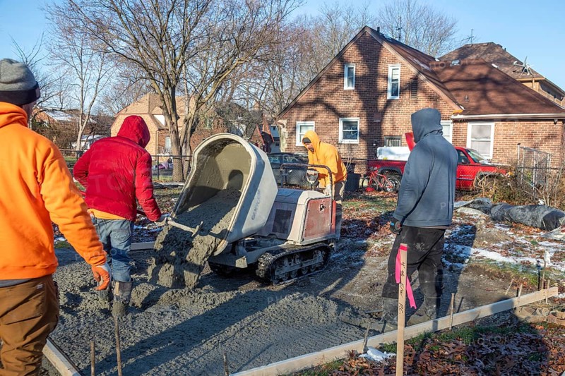 Detroit, Michigan - Workers pour and finish concrete for walking paths in Three Mile Park in Detroit's Morningside neighborhood.