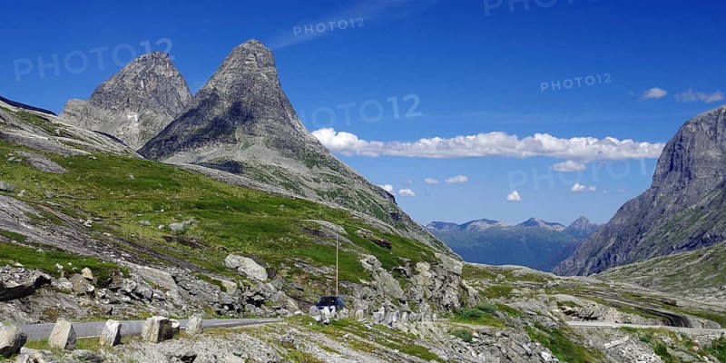 Two imposing mountain peaks rise into the blue sky, a road leads past, Trollstigen, Andalsnes, Norway, Europe